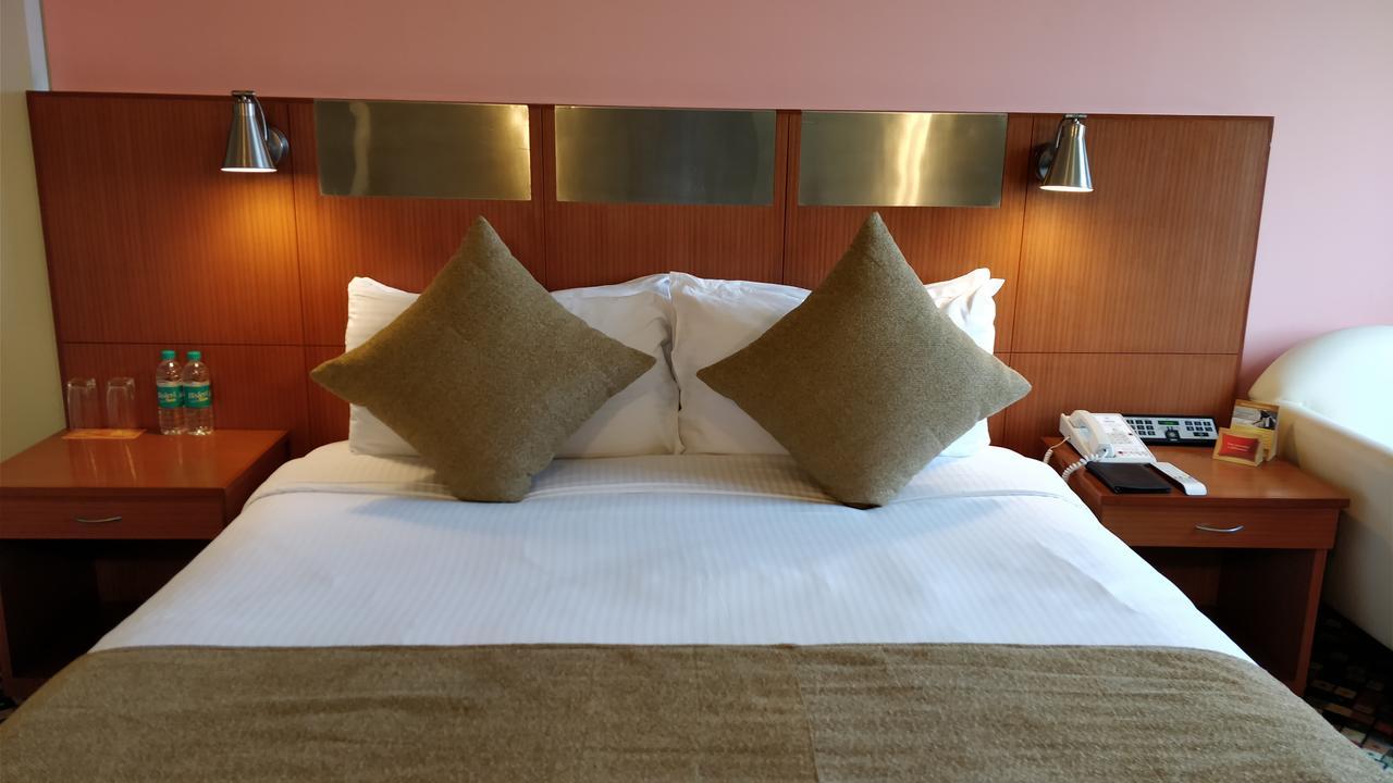 Отель The Suryaa Нью-Дели Экстерьер фото A bed in a hotel room